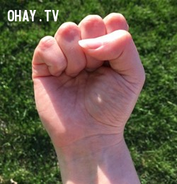 Ngón tay cái đặt trên ngón giữa khi nắm tay
