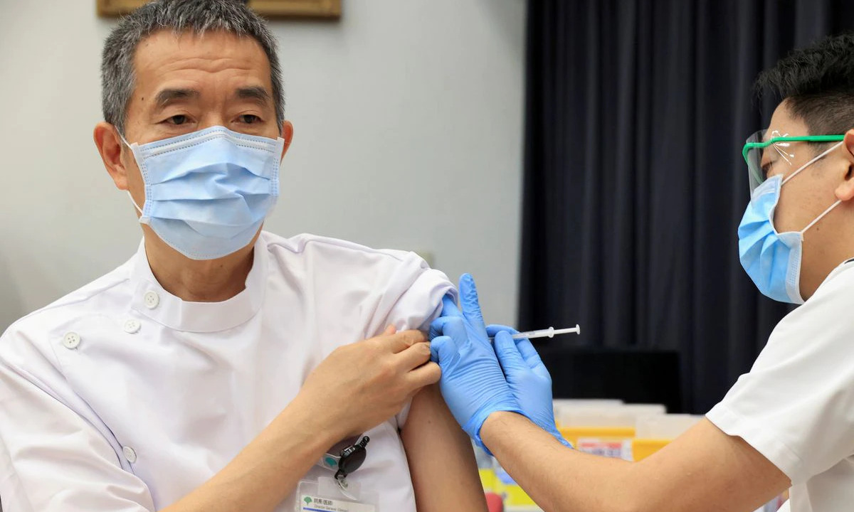 Một lãnh đạo cơ quan y tế Nhật tiêm vaccine tại Tokyo hồi tháng ba. Ảnh: Reuters