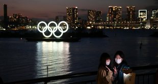 Người dân chụp ảnh với biểu tượng Olympic tại Tokyo. Ảnh: AP